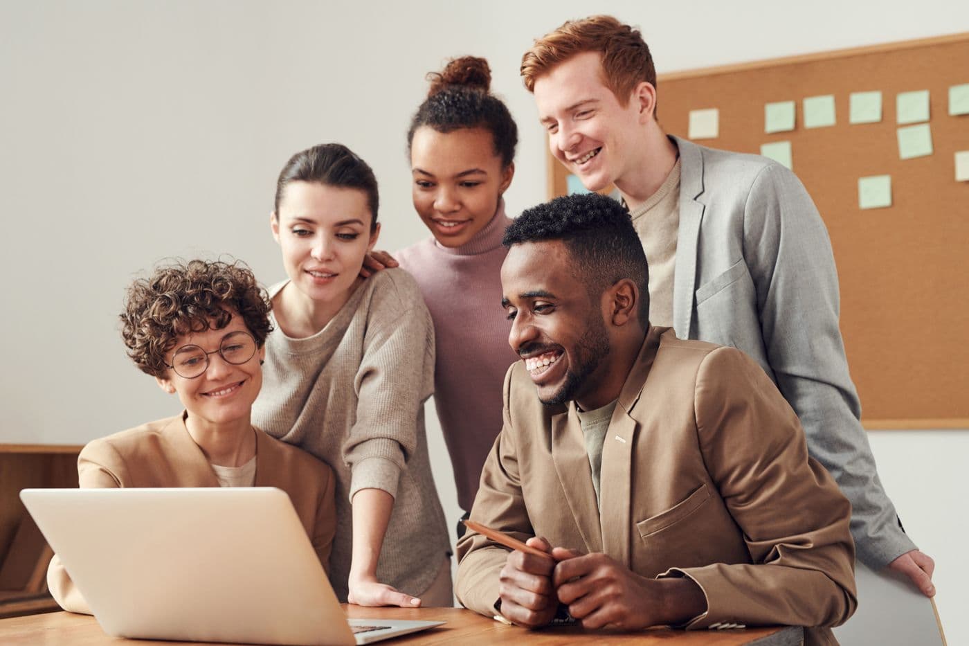 Des agents du service public réunis devant un ordinateur, souriants et sereins