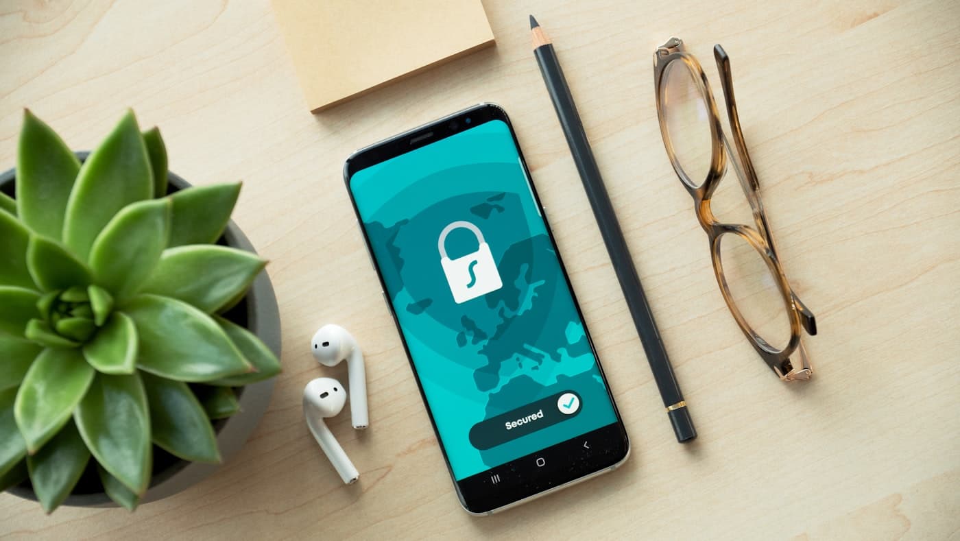 Un smartphone affichant un cadenas de protection des données, posé sur un bureau lumineux